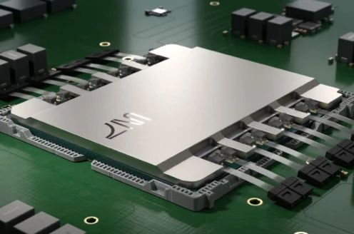 A large silver microchip on a green circuit board with several connected components.